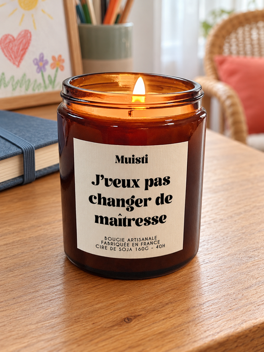 Bougie Muisti « J'veux pas changer de maîtresse » 160 g allumée dans un intérieur à la lumière douce du jour.