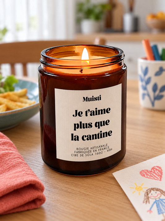 Bougie Muisti « Je t'aime plus que la cantine » 160 g allumée dans un intérieur à la lumière douce du jour.