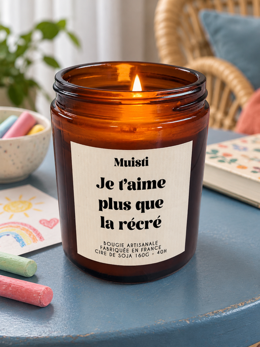 Bougie Muisti « Je t'aime plus que la récré » 160 g allumée dans un intérieur à la lumière douce du jour.