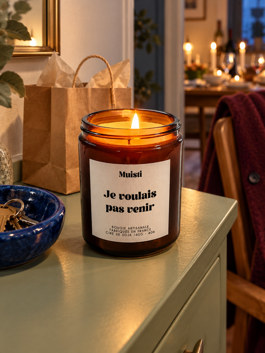 Bougie Muisti « Je voulais pas venir » allumée dans un décor de soirée.