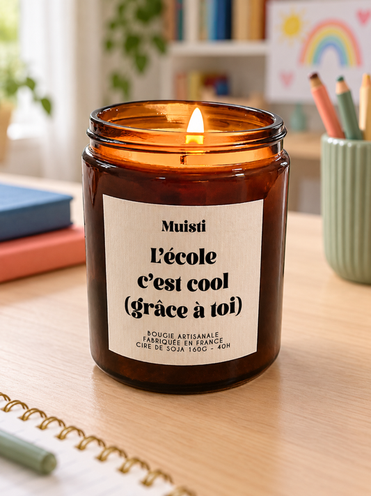Bougie Muisti « L'école c'est cool (grâce à toi) » 160 g allumée dans un intérieur à la lumière douce du jour.
