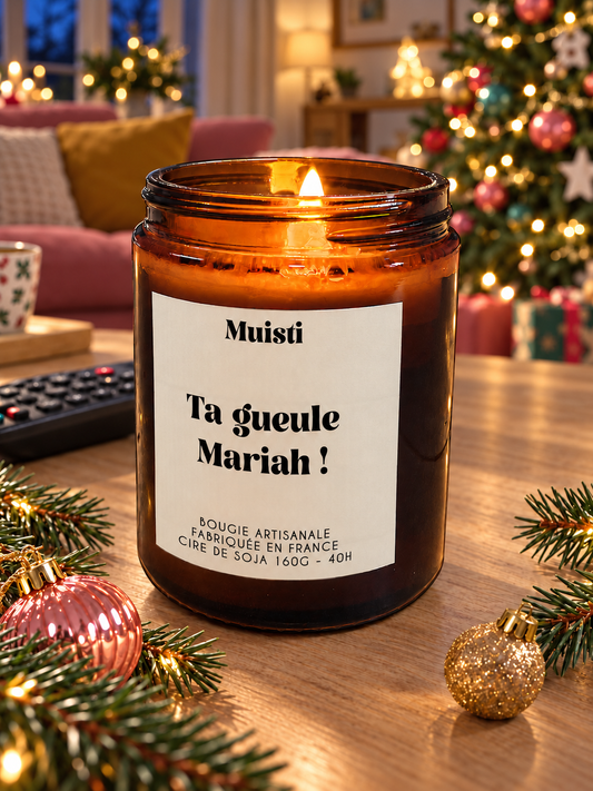 Bougie Muisti « Ta gueule Mariah ! » allumée dans un salon décoré pour Noël, en soirée.