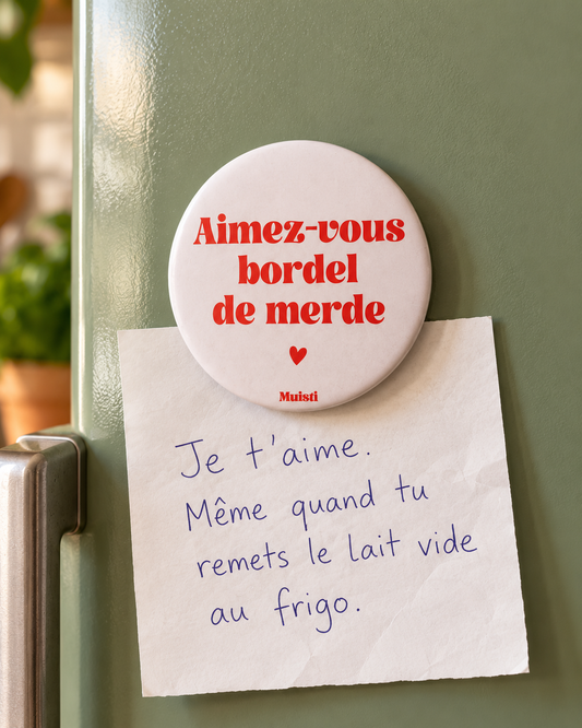 Magnet Muisti « Aimez-vous bordel de merde » tenant un petit mot dans une scène du quotidien.