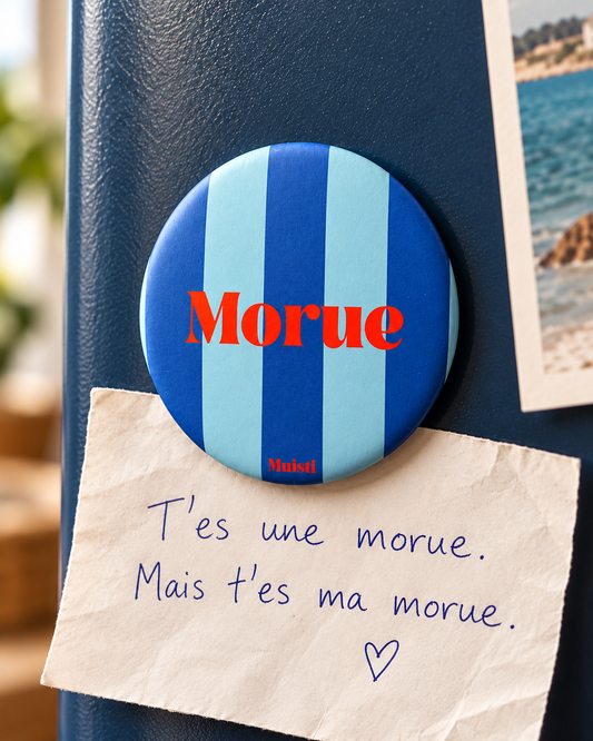 Magnet Muisti « Morue » tenant un petit mot dans une scène du quotidien.